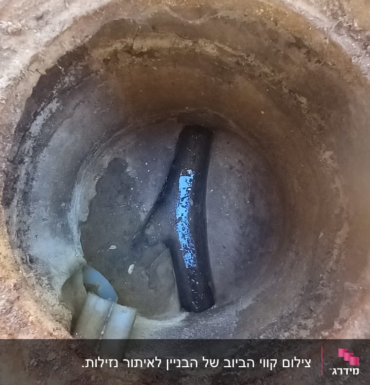 צינור שבור בתוך בור בטון עם חלודה